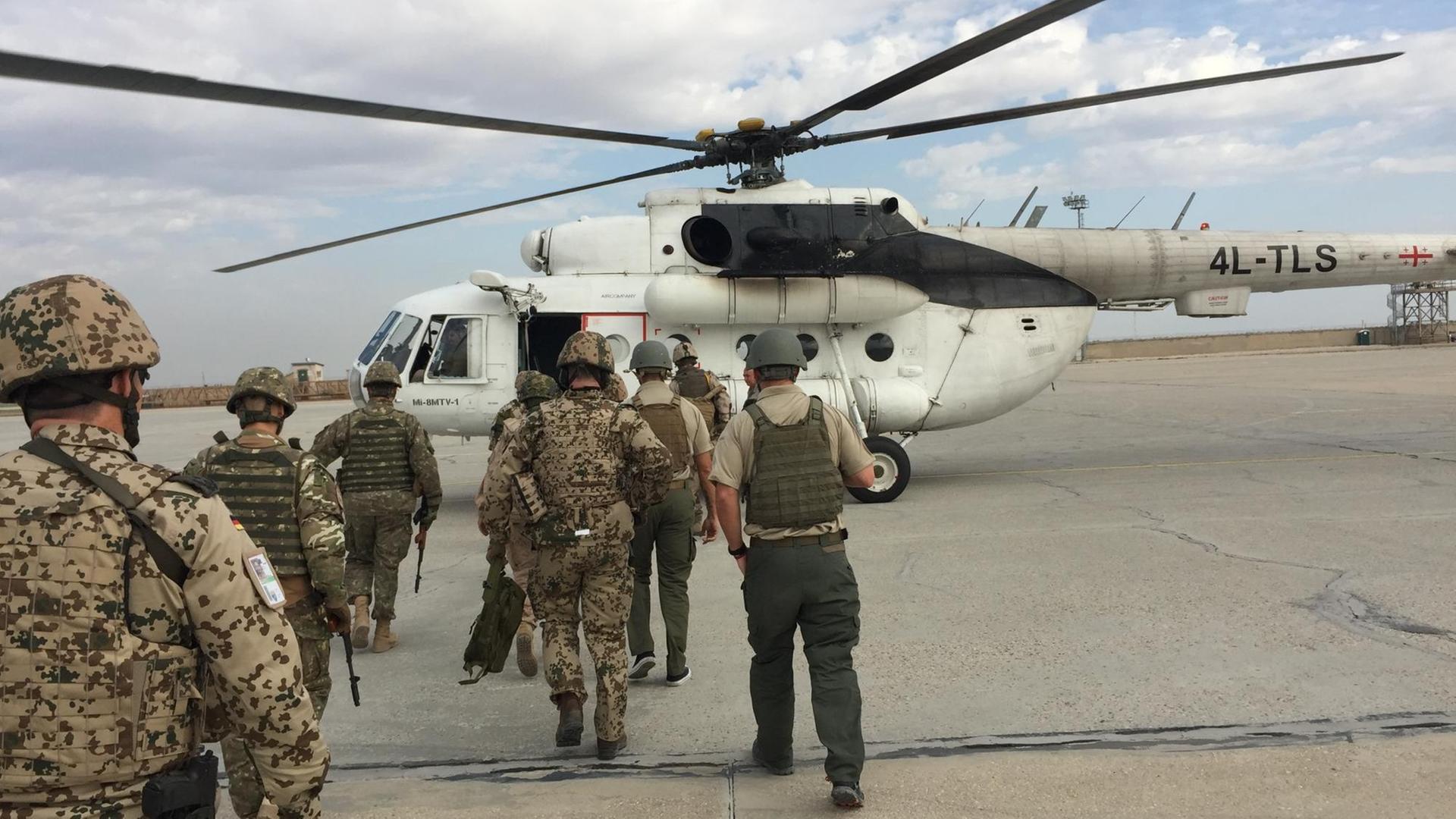 Mehrere Bundeswehrsoldaten gehen auf einen Hubschrauber zu Mehrere Bundeswehrsoldaten gehen auf einen Hubschrauber zu