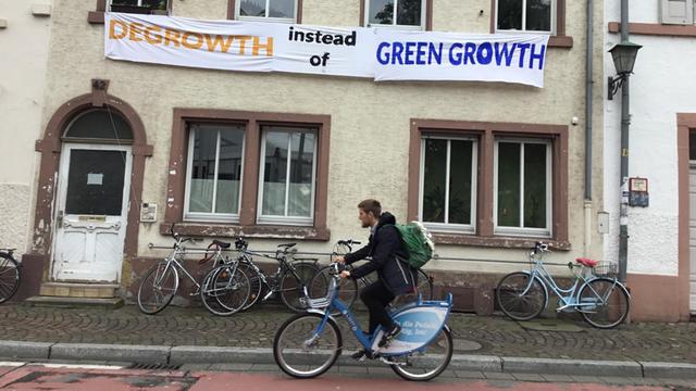 Transparent gegenüber der Heidelberger Kongresshalle zur Klimakonferenz ICCA, auf dem steht: „Degrowth statt Green Growth" – Wachstumsrücknahme statt grünes Wachstum