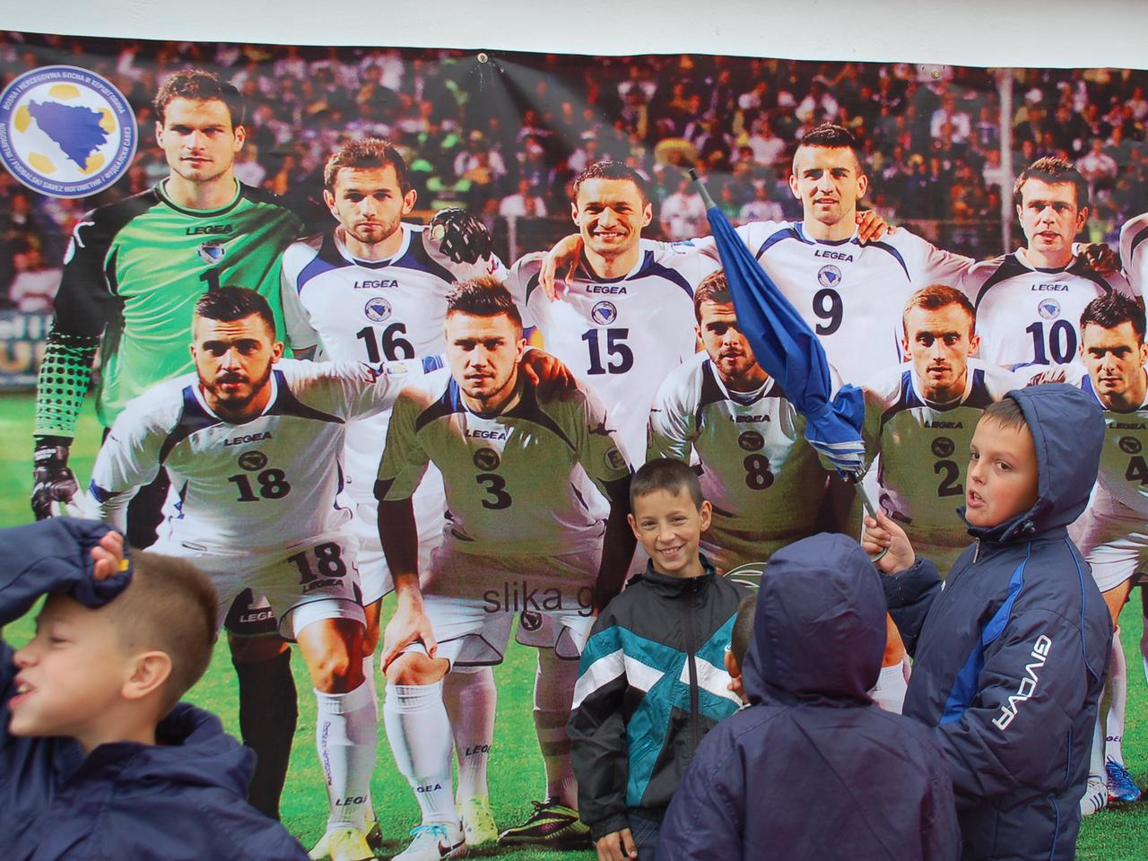 Kinder zeigen auf ein Plakat der bosnischen Nationalmannschaft Kinder zeigen auf ein Plakat der bosnischen Nationalmannschaft