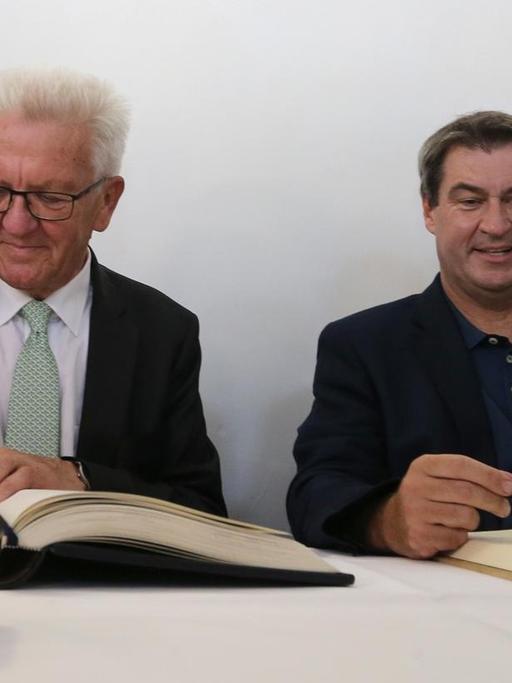 23.07.2019, Baden-Württemberg, Meersburg: Winfried Kretschmann, Ministerpräsident von Baden-Württemberg (Grüne,l) und Markus Söder, bayerischer Ministerpräsident (CSU) tragen sich in die Bücher der Stadt und des Landes ein. Foto: Karl-Josef Hildenbrand/dpa | Verwendung weltweit