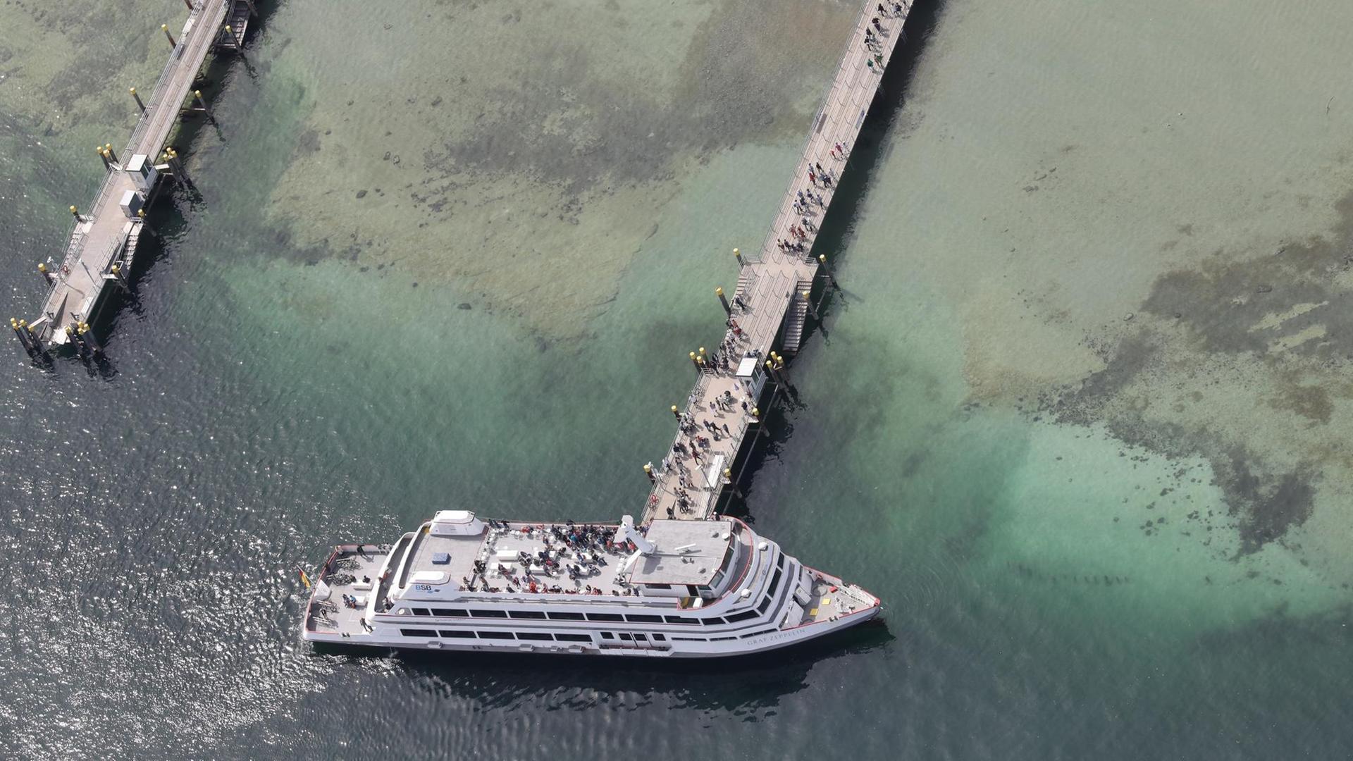 Besucher der Blumeninsel Mainau verlassen das Motorschiff Graf Zeppelin über einen Steg, der über den Bodensee führt. Besucher der Blumeninsel Mainau verlassen das Motorschiff Graf Zeppelin über einen Steg, der über den Bodensee führt.