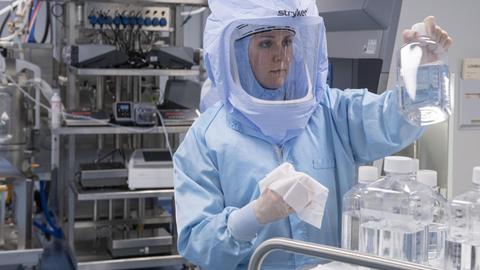 Mit Ganzkörper-Schutzanzügen simulieren Laborantinnen der Firma Biontech in einem Reinraum am neuen Produktionsstandort in Marburg die finalen Arbeitsschritte zur Herstellung des Corona-Impfstoffes an einem Bioreaktor.