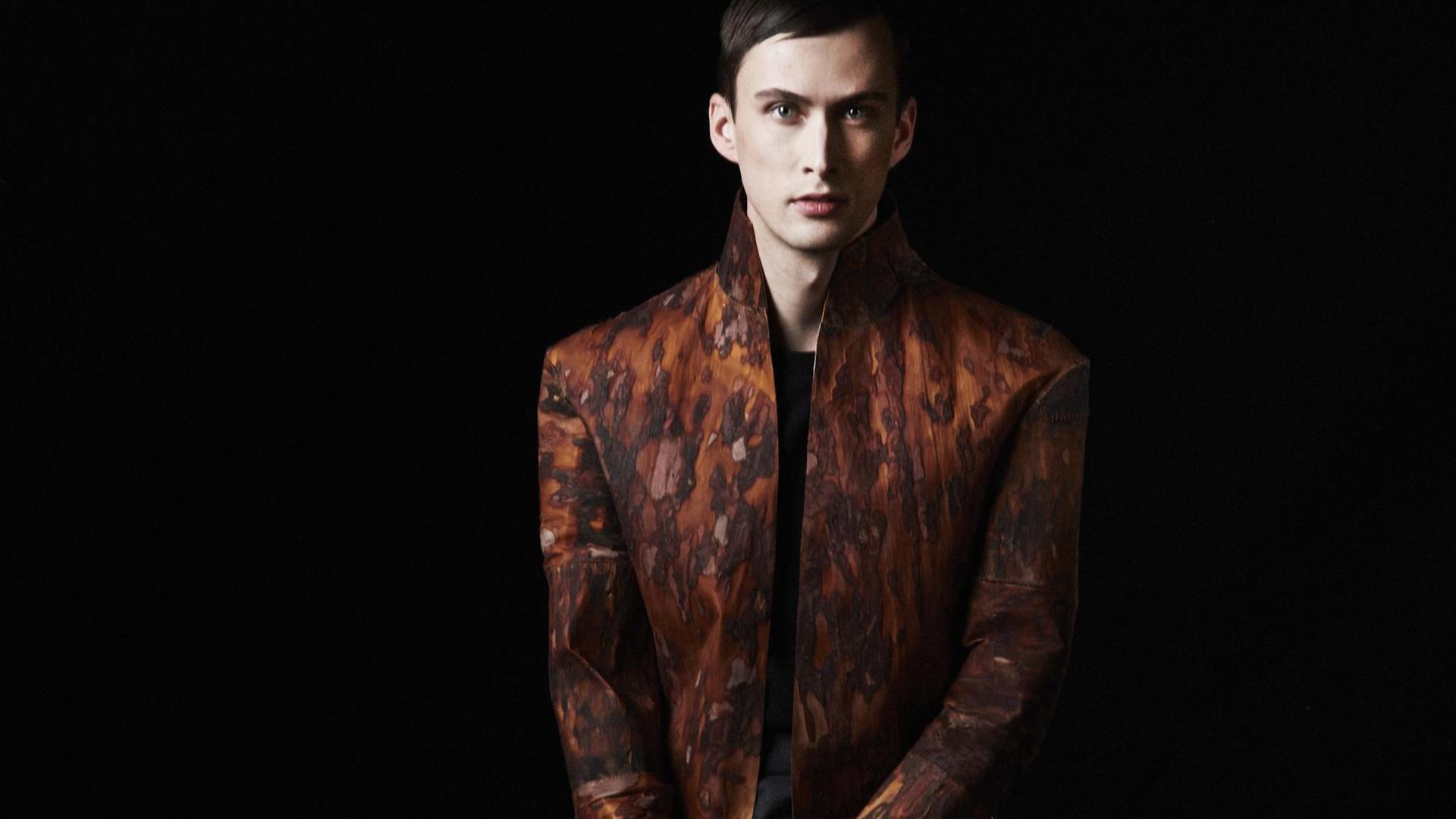 Ein männliches Model trägt eine Jacke aus gewebter Baumrinde.