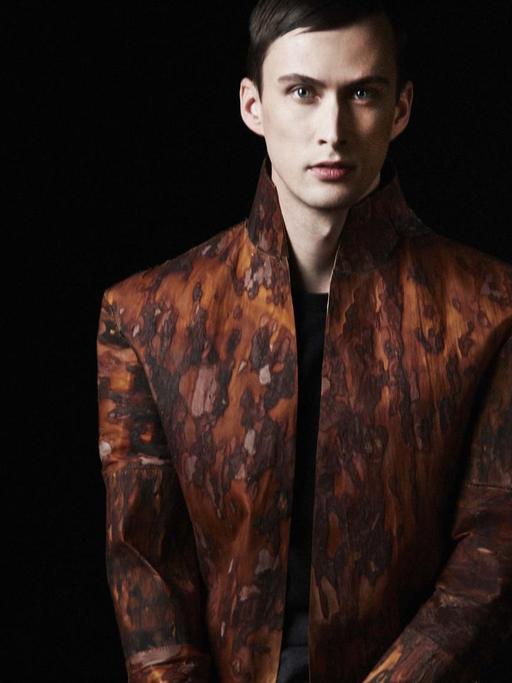 Ein männliches Model trägt eine Jacke aus gewebter Baumrinde.