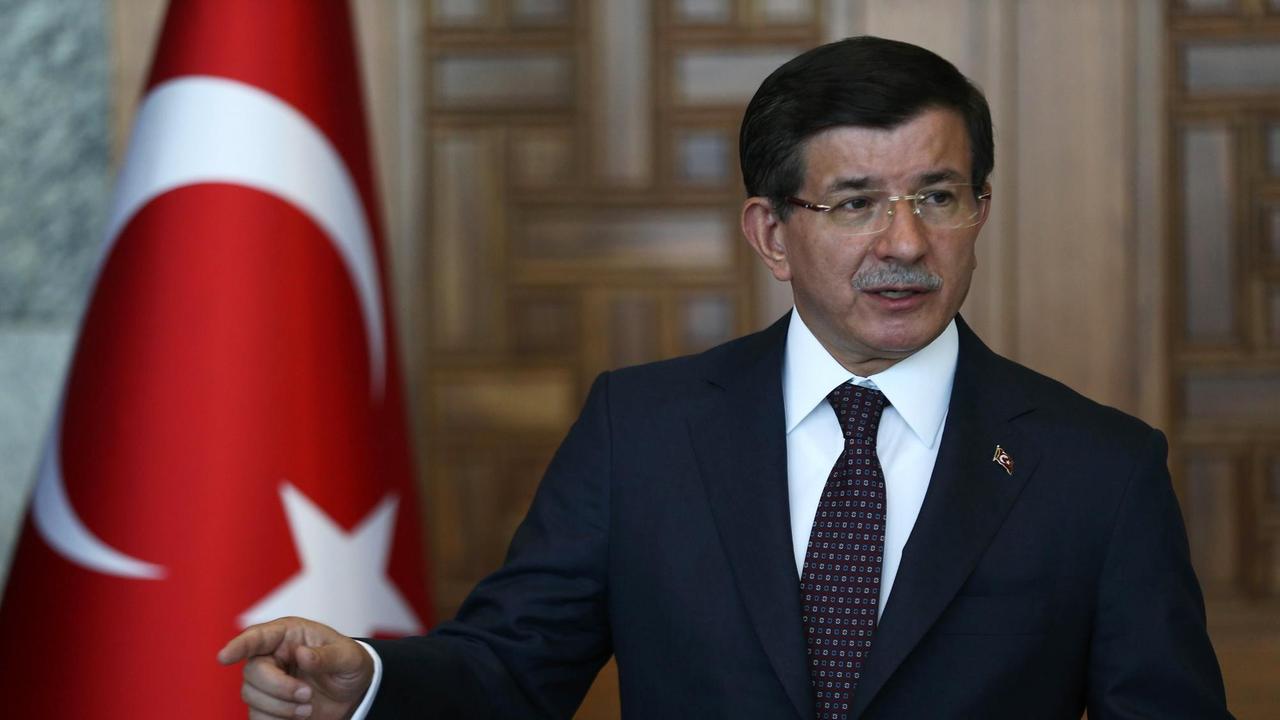 Ahmet Davutoglu spricht auf einer Pressekonferenz, hinter ihm die türkische Flagge.
