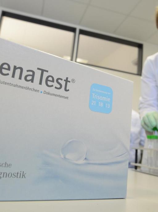 Eine Mitarbeiterin der Firma Lifecodexx ordnet Reagenzgläser. Im Vordergrund ist die Verpackung für den Trisomie-Bluttest der Firma zu sehen.