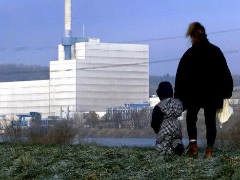 Eine Mutter geht mit ihrem Kind auf dem Elbdeich in der Samtgemeinde Marschacht entlang. Im Hintergrund das Atomkraftwerk Krümmel bei Geesthacht.