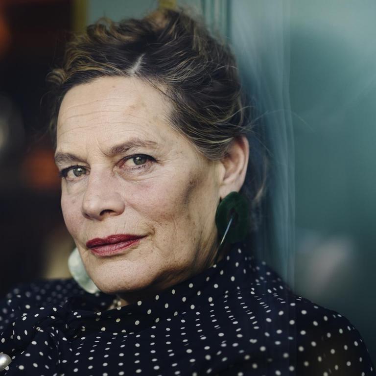Die Schriftstellerin Deborah Levy, aufgenommen 2019 in Stockholm. Sie trägt ihr grau-meliertes Haar hochsteckt.