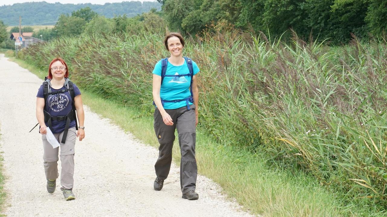 Zwei Frauen laufen einen Wanderweg entlang. Zwei Frauen laufen einen Wanderweg entlang.