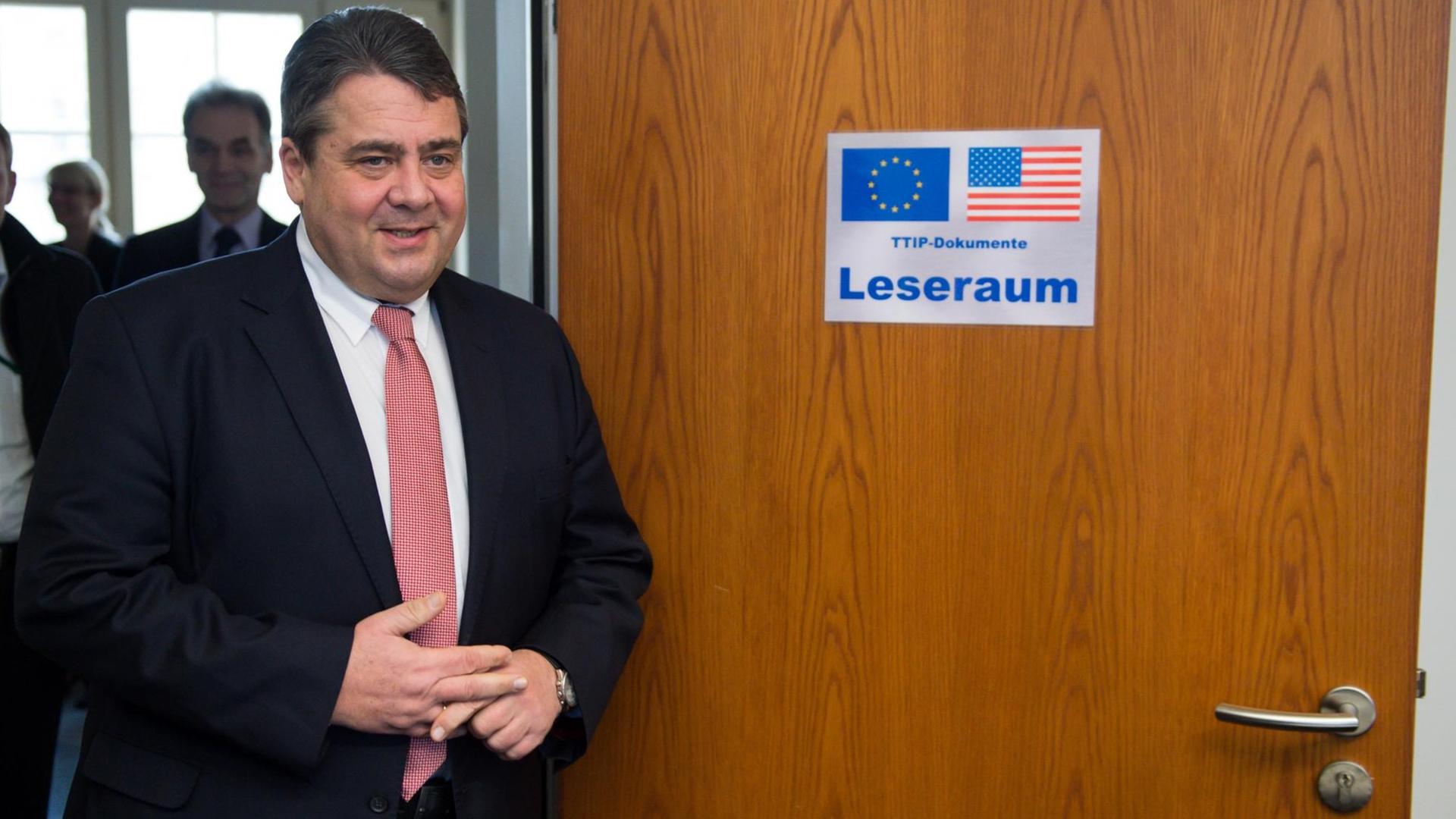 Bundeswirtschaftsminister Sigmar Gabriel (SPD) vor einer Holztür mit der Aufschrift "Leseraum" und der US- und EU-Flagge. Bundeswirtschaftsminister Sigmar Gabriel (SPD) vor einer Holztür mit der Aufschrift "Leseraum" und der US- und EU-Flagge.