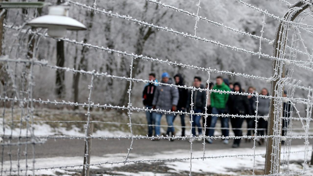 Jugendliche gehen hinter dem Stacheldrahtzaun am 08.02.2017 in der Gedenkstätte Buchenwald in Weimar. Jugendliche gehen hinter dem Stacheldrahtzaun am 08.02.2017 in der Gedenkstätte Buchenwald in Weimar.