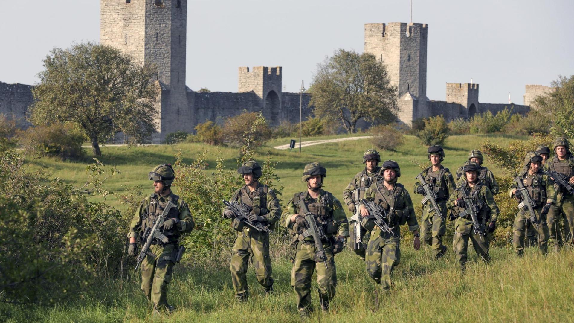 Eine Einheit des Skarabourg Regiments patrouillert außerhalb der historischen Stadtmauer von Visby auf der schwedischen Insel Gotland Eine Einheit des Skarabourg Regiments patrouillert außerhalb der historischen Stadtmauer von Visby auf der schwedischen Insel Gotland