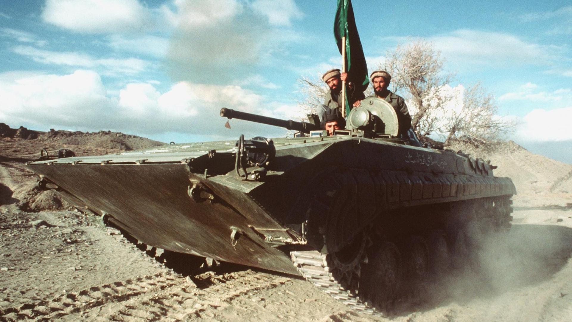 Panzer, auf dem drei Männer sitzen und eine grüne Fahne hissen Panzer, auf dem drei Männer sitzen und eine grüne Fahne hissen
