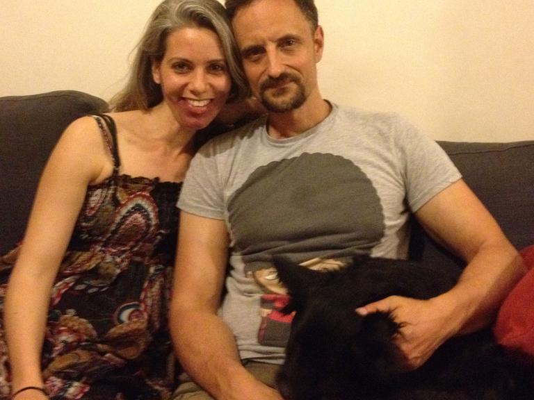 Die 36-jährige Nina und der 42-jährige Sascha auf dem Sofa mit ihrem Hund in ihrer Wohnung in Tel Aviv.