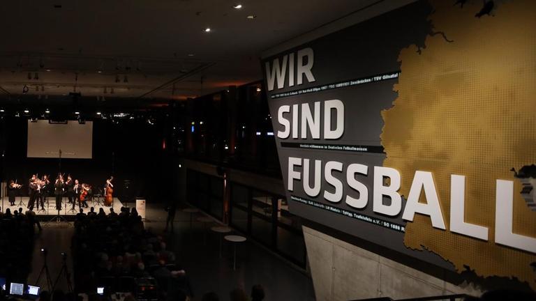 Im Saal des Deutschen Fußball-Museums spielt ein Orchester. Im Saal des Deutschen Fußball-Museums spielt ein Orchester.