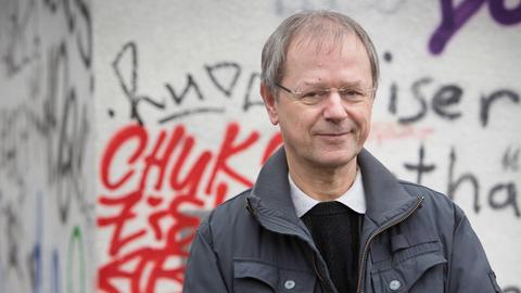 Christoph Butterwegge, Politikwissenschaftler und Armutsforscher, steht vor einer mit Graffitis besprühten Mauer
