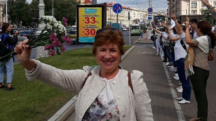 Marina hebt ihre Blumen in der Hand hoch und lächelt in die Kamera. Marina hebt ihre Blumen in der Hand hoch und lächelt in die Kamera.
