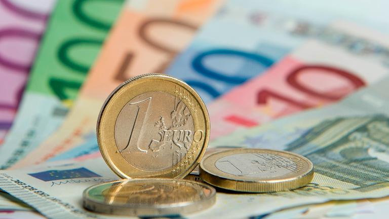 Euroscheine und Euromünzen liegen auf einem Tisch. Euroscheine und Euromünzen liegen auf einem Tisch.