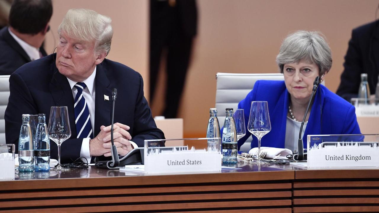 Der US-amerikanische Präsident Donald Trump und die britische Premierministerin Theresa May sitzen zu Beginn der ersten Arbeitssitzung beim G20-Gipfel am 07.07.2017 in Hamburg nebeneinander.