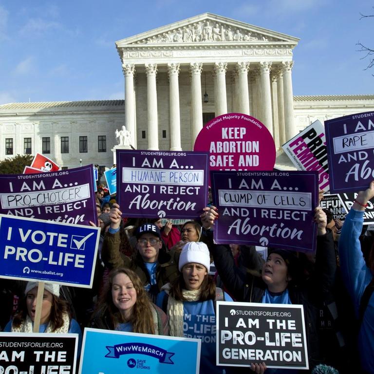 Frauen halten Schilder mit Botschaften gegen Abtreibung in die Höhe, dahinter sieht man das Oberste Gericht.