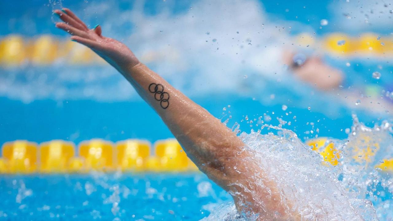 Die Olympischen Ringe zieren in Form eines Tatoos den Arm eines Rückenschwimmers Die Olympischen Ringe zieren in Form eines Tatoos den Arm eines Rückenschwimmers