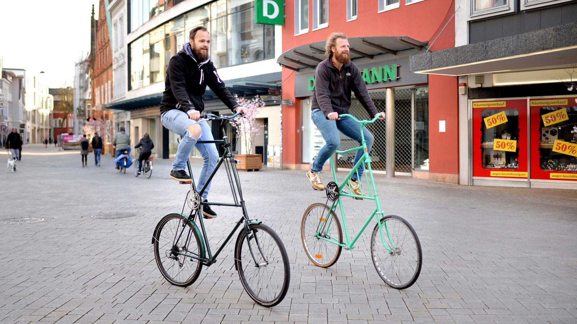 Zwei Männer fahren mit ihren Hochrädern durch die nahezu menschenleere Innenstadt in Oldenburg.