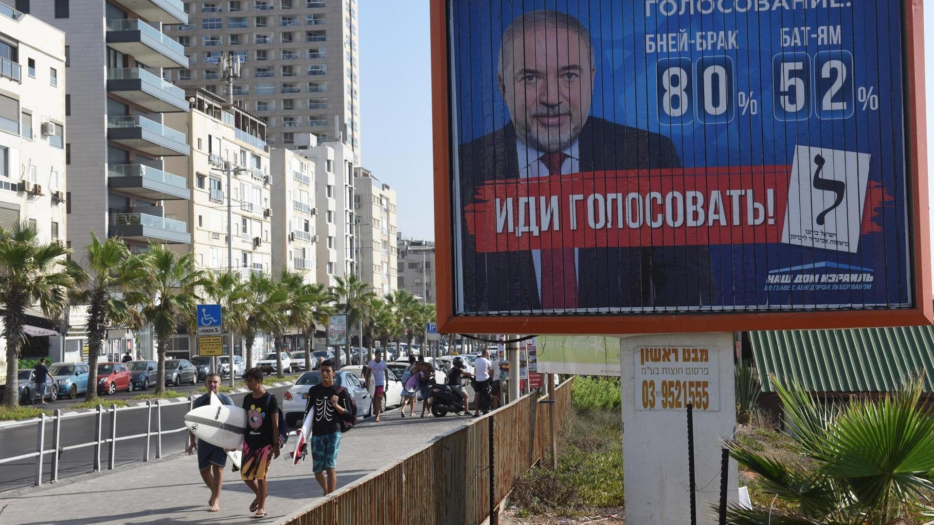 Israelis laufen an einem Wahlplakat des Vertreters der russischstämmigen Juden, Avigdor Lieberman, vorbei, aufgenommen im September 2019