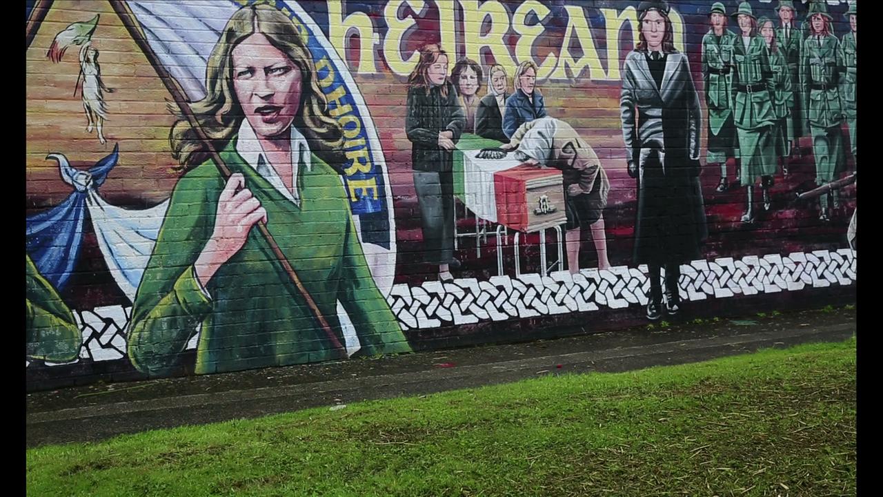 Still aus dem Film "The Long Note" (2018) der britischen Künstlerin Helen Cammock. Eine Ziegelwand in Londonderry zeigt ein Gemälde mit Frauen der Bürgerrechtsbewegung "Northern Ireland Civil Rights Association". Still aus dem Film "The Long Note" (2018) der britischen Künstlerin Helen Cammock. Eine Ziegelwand in Londonderry zeigt ein Gemälde mit Frauen der Bürgerrechtsbewegung "Northern Ireland Civil Rights Association".