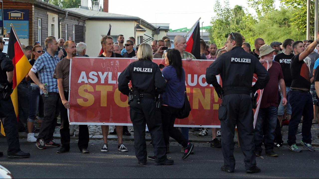 Zu sehen sind Menschen, die im Juli 2015 in Dresden gegen ein Zeltlager für Flüchtlinge demonstrieren Zu sehen sind Menschen, die im Juli 2015 in Dresden gegen ein Zeltlager für Flüchtlinge demonstrieren