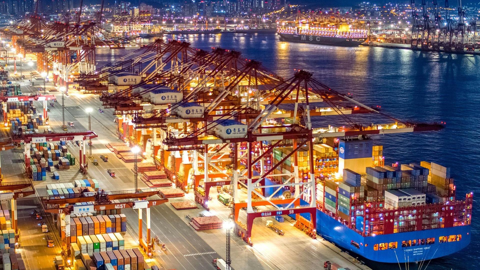 China, Qingdao: Containerschiffe liegen am nächtlich beleuchteten Containerterminal des Hafens von Qingdao. China, Qingdao: Containerschiffe liegen am nächtlich beleuchteten Containerterminal des Hafens von Qingdao.