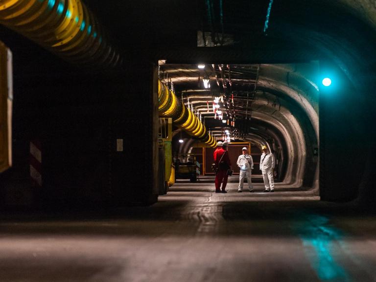Bergleute und Gäste stehen im ehemaligen Erkundungsbergwerk Salzstock Gorleben.