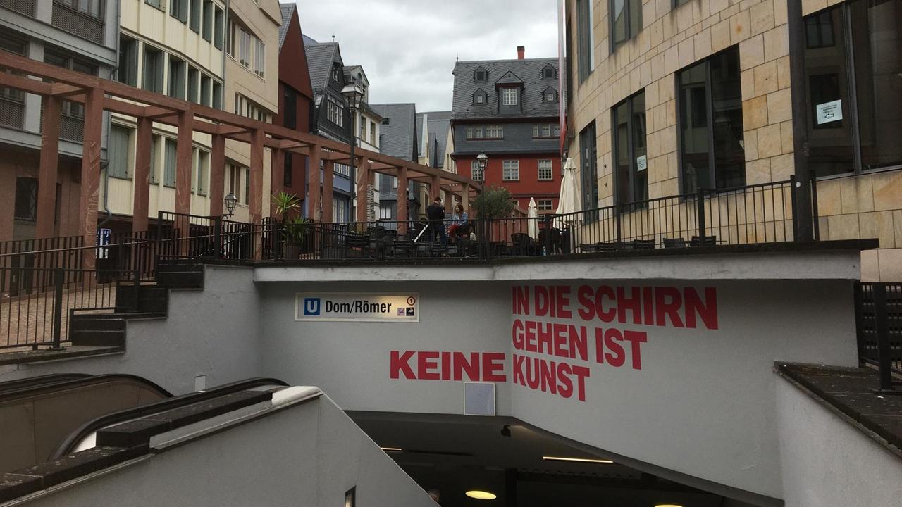 Die Braubachstraße in der neuen Frankfurter Altstadt mit dem Museum für Moderne Kunst. Am Eingang zur U-Bahnstation steht "In die Schirn gehen ist keine Kunst".