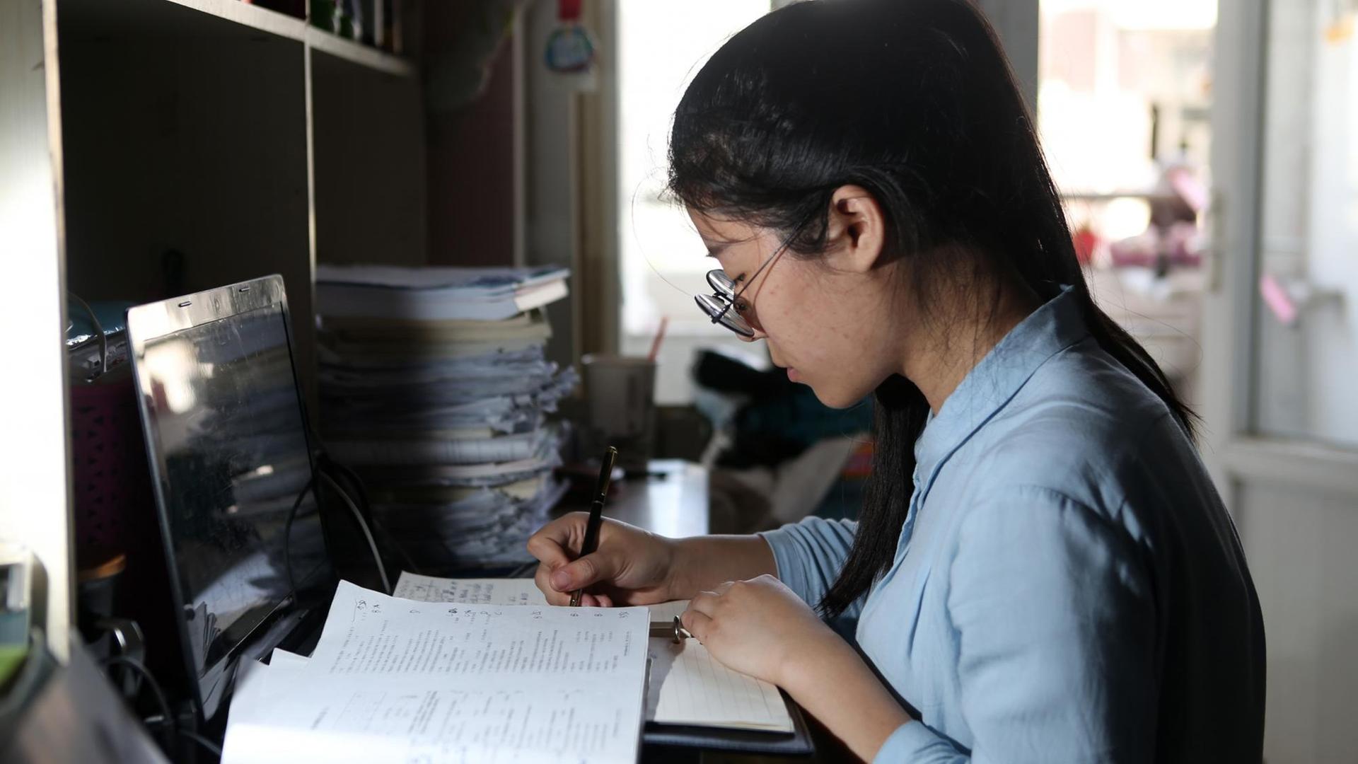Die chinesische Studentin Tang Lisha sitzt am Schreibtisch und lernt im Studentenwohnheim der Chengdu Normal University Die chinesische Studentin Tang Lisha sitzt am Schreibtisch und lernt im Studentenwohnheim der Chengdu Normal University
