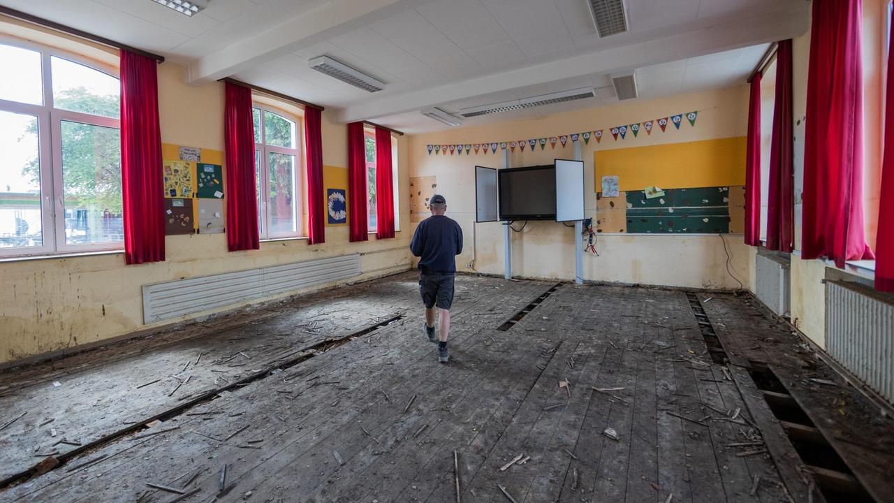 Hausmeister Günter Reiz geht durch einen zerstörten Klassenraum der Swistbachschule in Swisttal-Heimerzheim