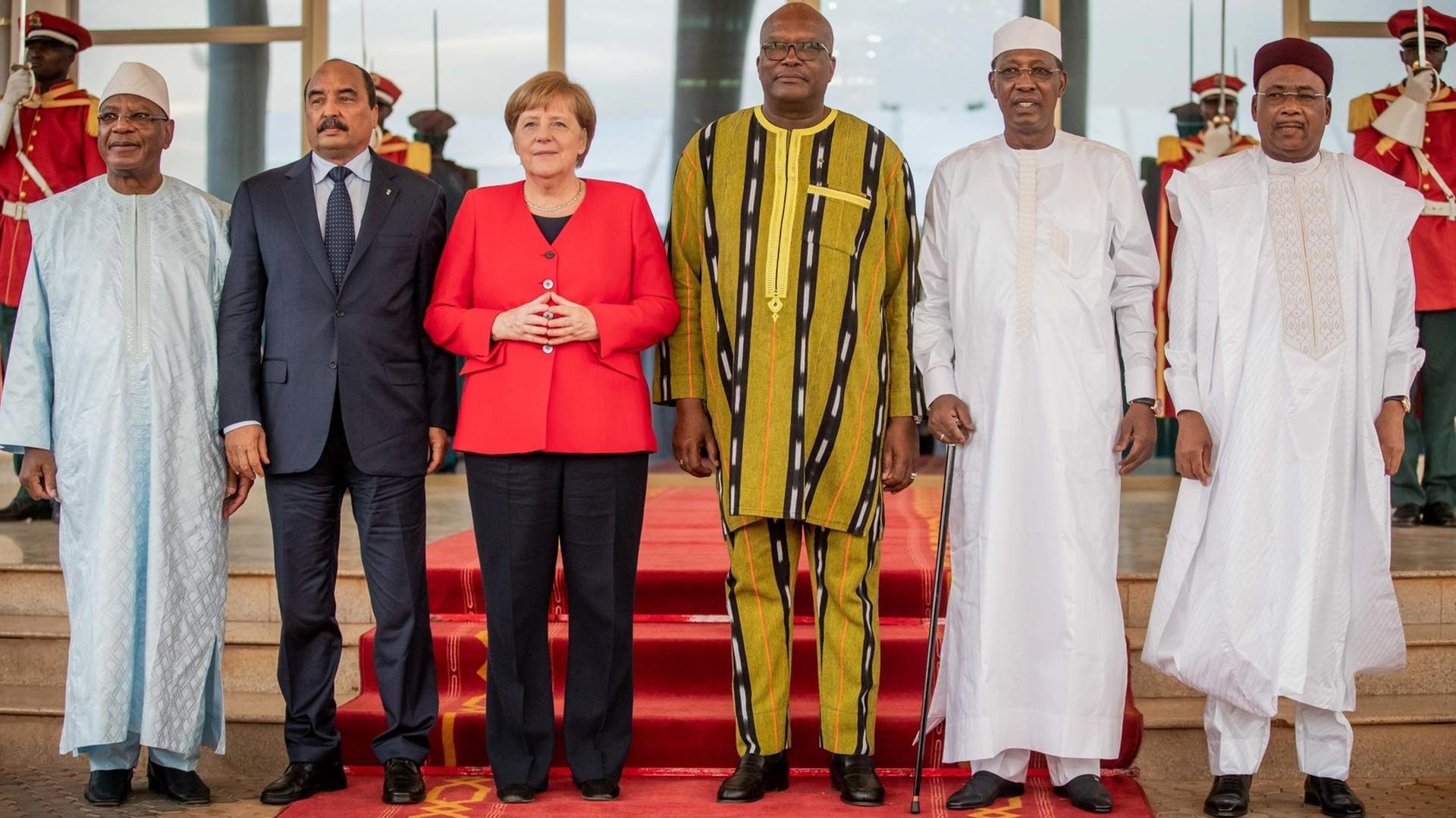 01.05.2019, Burkina Faso, Ouagadougou: Bundeskanzlerin Angela Merkel (CDU) steht mit Roch Marc Kabore (M), Präsident von Burkina Faso, Ibrahim Boubacar Keita (l), Präsident von Mali, Mohamed Ould Abdel Aziz (2.v.l.), Präsident von Mauretanien, Mahamadou Issoufou (r), Präsident vom Niger, und Idriss Deby (2.v.r.), Präsident des Tschad beim Treffen der Regionalorganisation G5 Sahel zusammen. Foto: Michael Kappeler/dpa | Verwendung weltweit 01.05.2019, Burkina Faso, Ouagadougou: Bundeskanzlerin Angela Merkel (CDU) steht mit Roch Marc Kabore (M), Präsident von Burkina Faso, Ibrahim Boubacar Keita (l), Präsident von Mali, Mohamed Ould Abdel Aziz (2.v.l.), Präsident von Mauretanien, Mahamadou Issoufou (r), Präsident vom Niger, und Idriss Deby (2.v.r.), Präsident des Tschad beim Treffen der Regionalorganisation G5 Sahel zusammen. Foto: Michael Kappeler/dpa | Verwendung weltweit