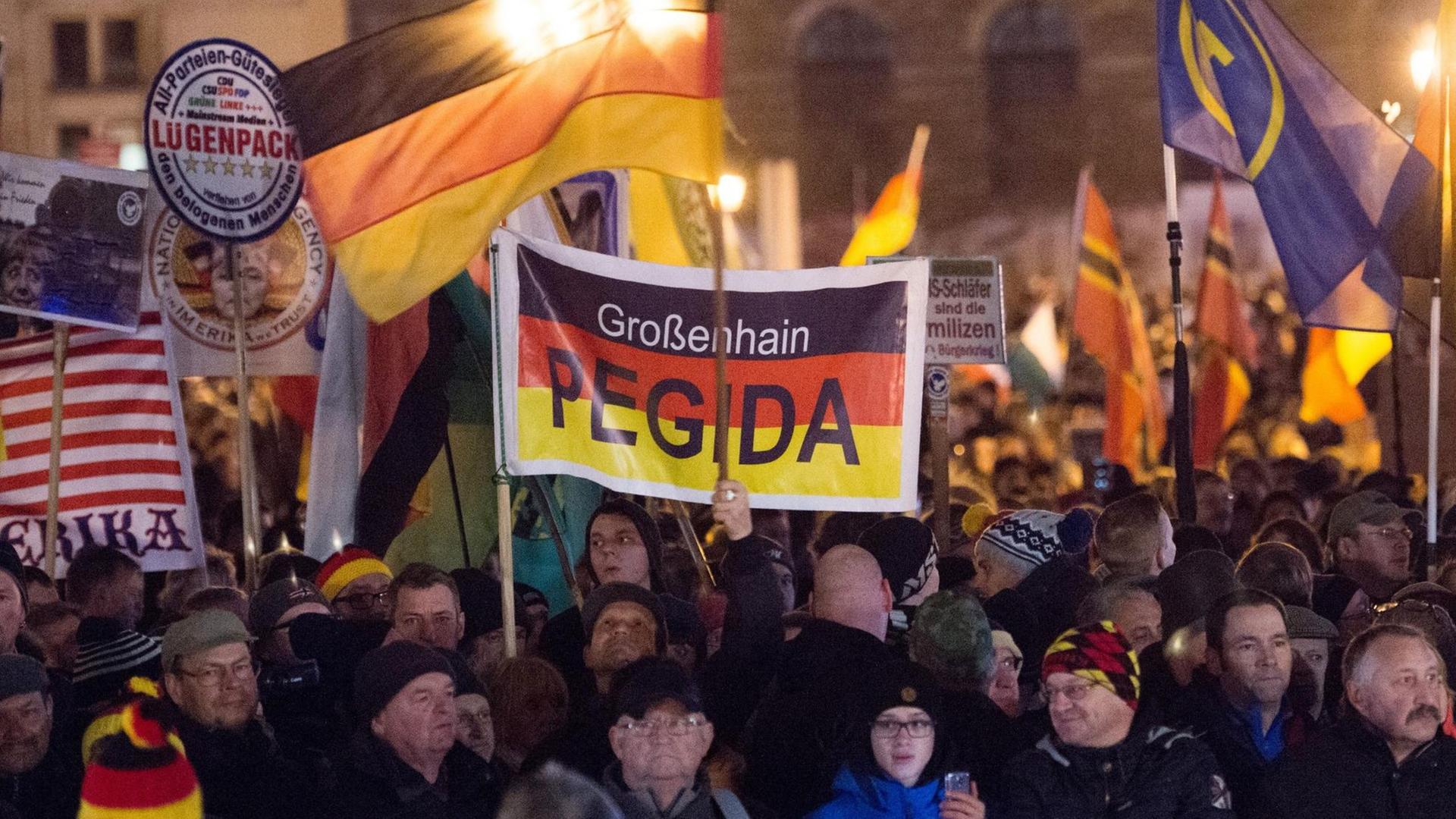 Teilnehmer haben sich am 14.12.2015 auf dem Theaterplatz in Dresden während einer Kundgebung des Bündnisses Pegida versammelt. Teilnehmer haben sich am 14.12.2015 auf dem Theaterplatz in Dresden während einer Kundgebung des Bündnisses Pegida versammelt.