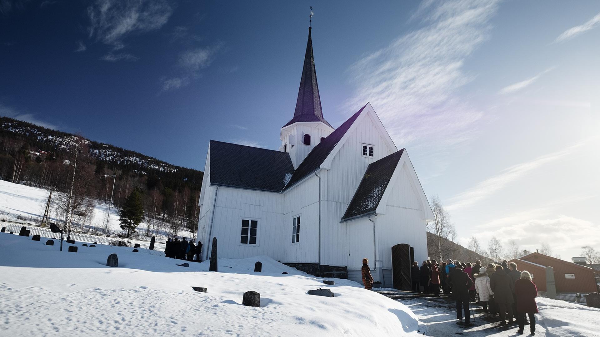 Menschenschlange vor einer norwegischen Bergkirche im Schnee