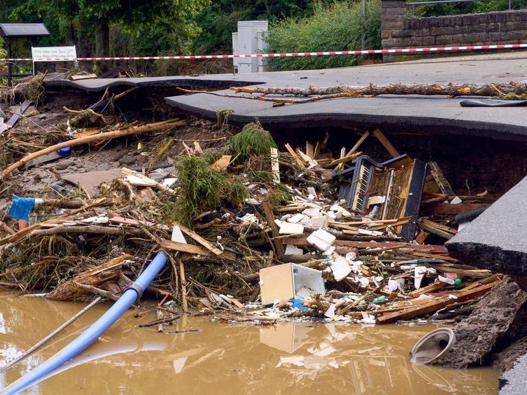 Ein Klavier liegt im Schutt unter einer unterspülten Straße im Kreis Ahrweiler am Tag nach dem Unwetter mit Hochwasser. Mindestens sechs Häuser wurden durch die Fluten zerstört.