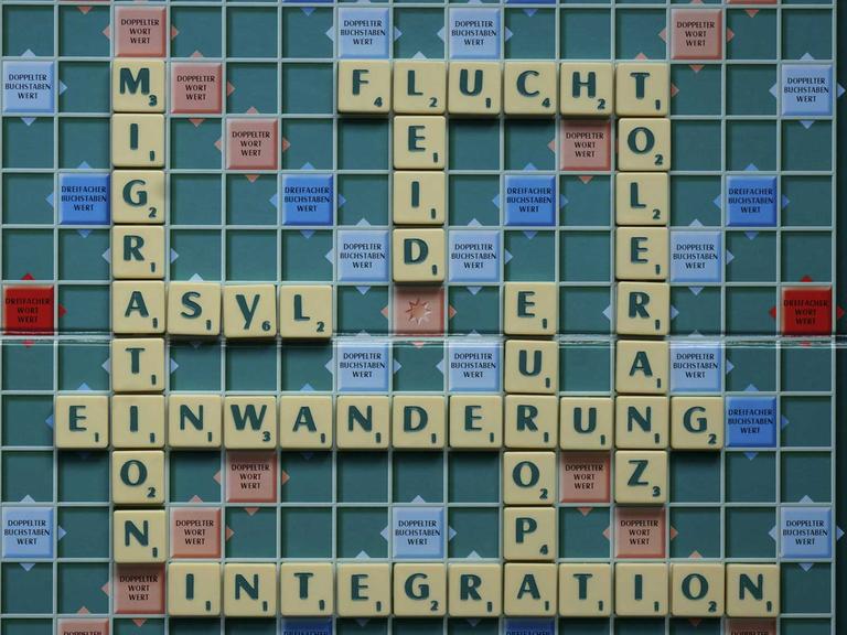 Scrabblespiel mit den Worten Einwanderungspolitik, Einwanderung, Migration, Asyl, Integration, Europa, Toleranz, Flucht, Leid