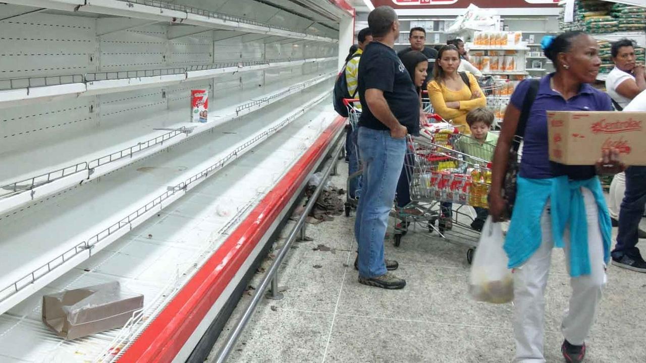 Kunden stehen im Supermarkt in Caracas, Venezuela, vor leeren Regalen. Kunden stehen im Supermarkt in Caracas, Venezuela, vor leeren Regalen.