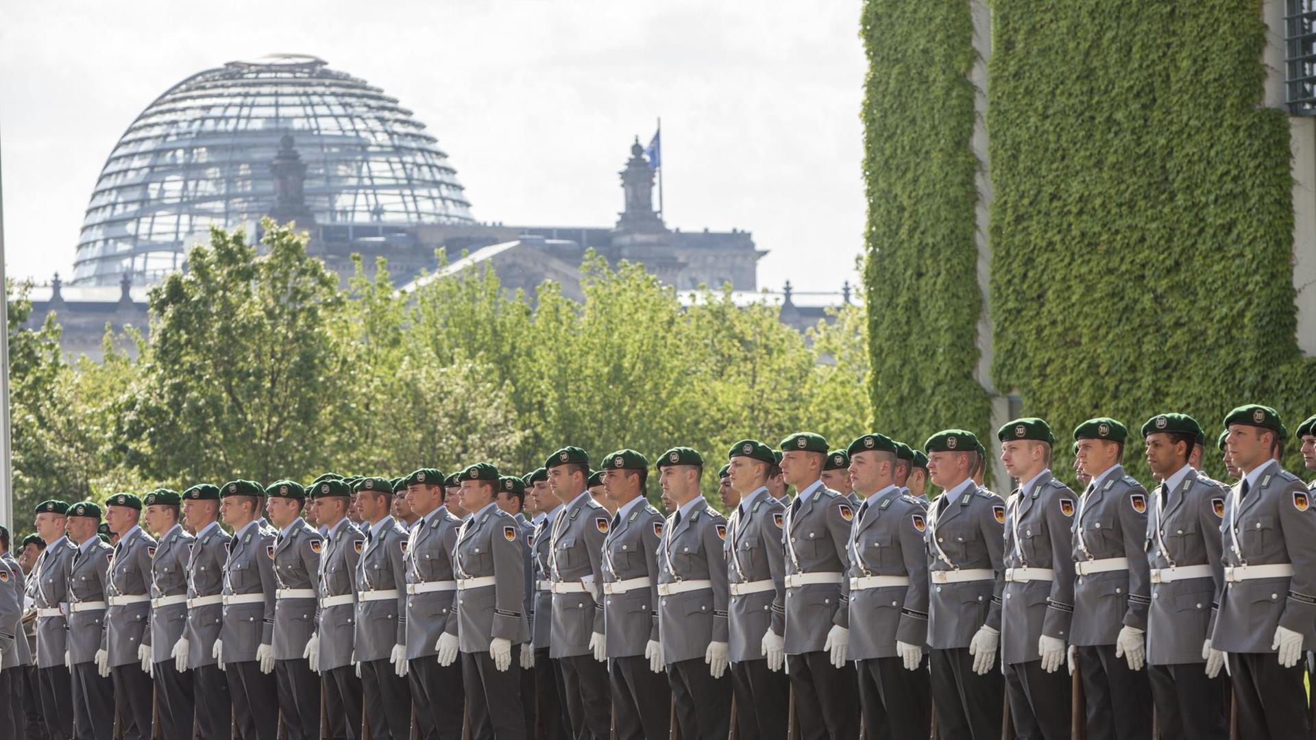 Bundeswehr-Soldaten stehen in einer Reihe, im Hintergrund ist die Reichstagskuppel in Berlin zu erkennen. Bundeswehr-Soldaten stehen in einer Reihe, im Hintergrund ist die Reichstagskuppel in Berlin zu erkennen.