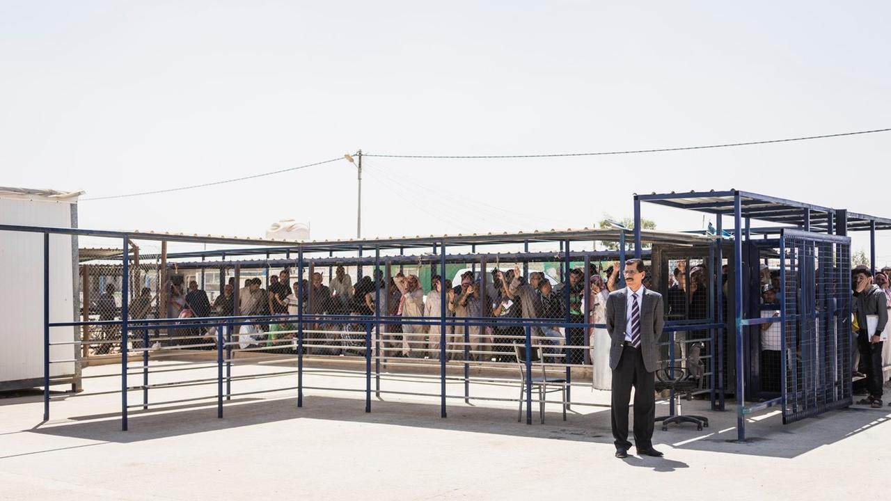Menschen stehen dicht gedrängt und eingezäunt im Zaatari Flüchtlingslager in Jordanien Menschen stehen dicht gedrängt und eingezäunt im Zaatari Flüchtlingslager in Jordanien