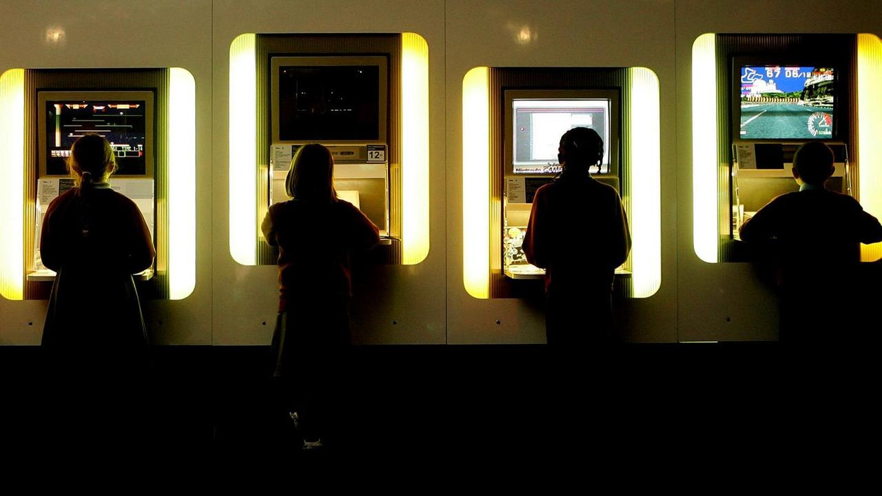 Kinder spielen am Computer im Science Museum London und sind von hinten zu sehen. Kinder spielen am Computer im Science Museum London und sind von hinten zu sehen.