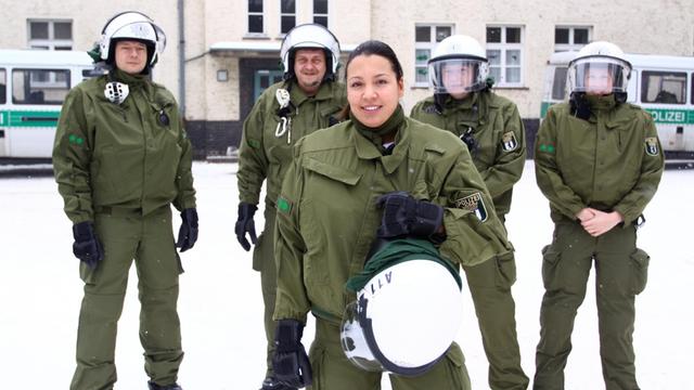 Heidi, Berliner Polizistin mit türkischem Migrationshintergrund, posiert mit Kollegen.