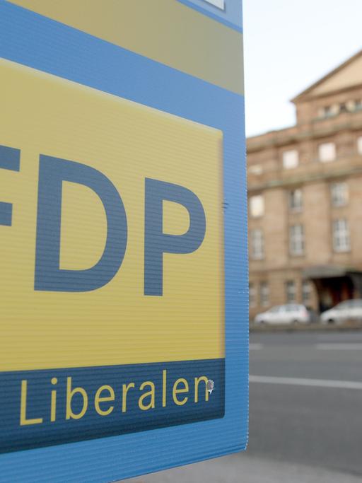 Ein Plakat mit dem Logo der Partei FDP hängt am 05.01.2015 vor dem Opernhaus in Stuttgart.