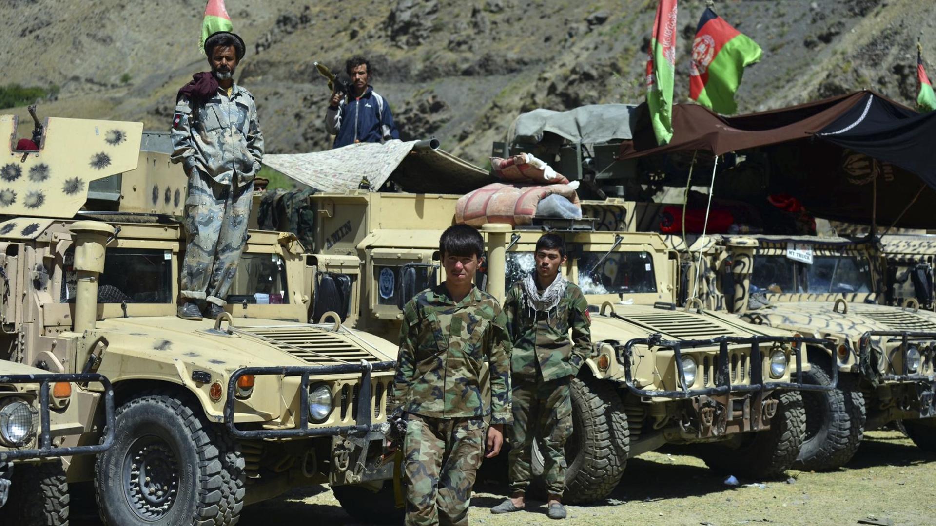 Anhänger von Ahmad Massoud, Sohn des verstorbenen Ahmad Shah Massoud, im Panjshir-Tal. Stark bewaffnete Kämpfer stehen vor einer Reihe von Jeeps. Anhänger von Ahmad Massoud, Sohn des verstorbenen Ahmad Shah Massoud, im Panjshir-Tal. Stark bewaffnete Kämpfer stehen vor einer Reihe von Jeeps.