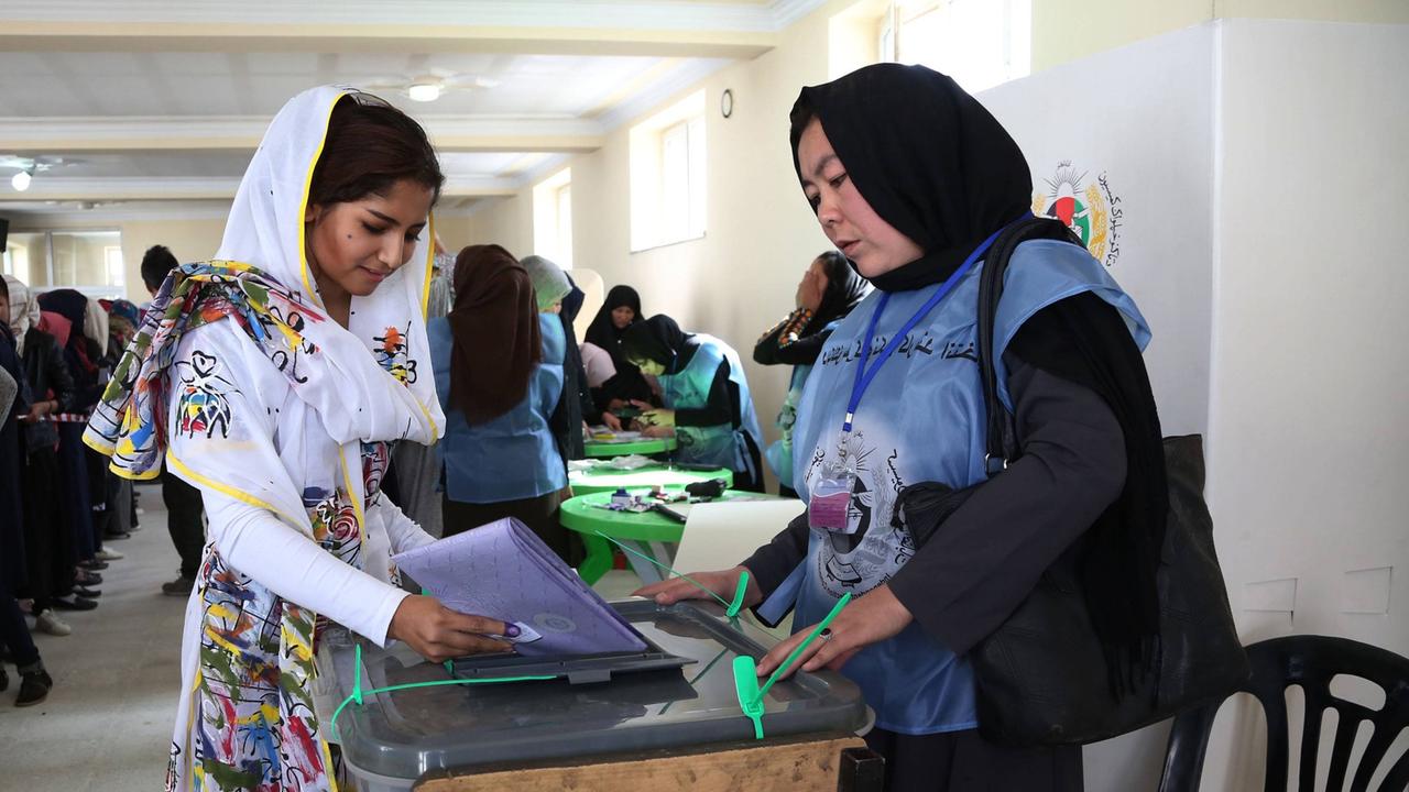 Eine junge Frau wirft bei der afghanischen Parlamentswahl im Oktober 2018 in der Hauptstadt Kabul ihren Wahlumschlag ein. Eine junge Frau wirft bei der afghanischen Parlamentswahl im Oktober 2018 in der Hauptstadt Kabul ihren Wahlumschlag ein.