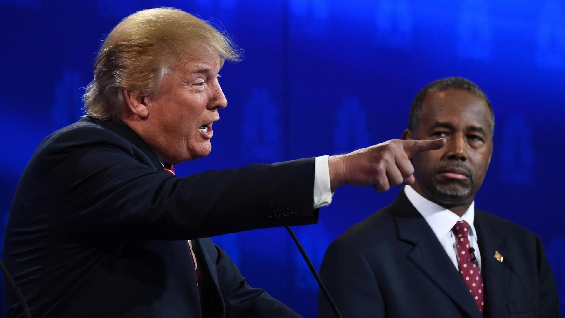 Die beiden Bewerber um die Präsidentschaftskandidatur der Republikaner, Donald Trump und Ben Carson, während einer TV-Debatte. Die beiden Bewerber um die Präsidentschaftskandidatur der Republikaner, Donald Trump und Ben Carson, während einer TV-Debatte.