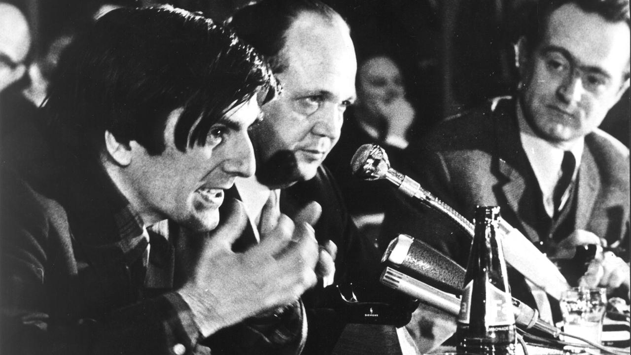 Rudi Dutschke spricht bei einer Veranstaltung auf dem Podium in ein Mikrofon. Rudi Dutschke spricht bei einer Veranstaltung auf dem Podium in ein Mikrofon.