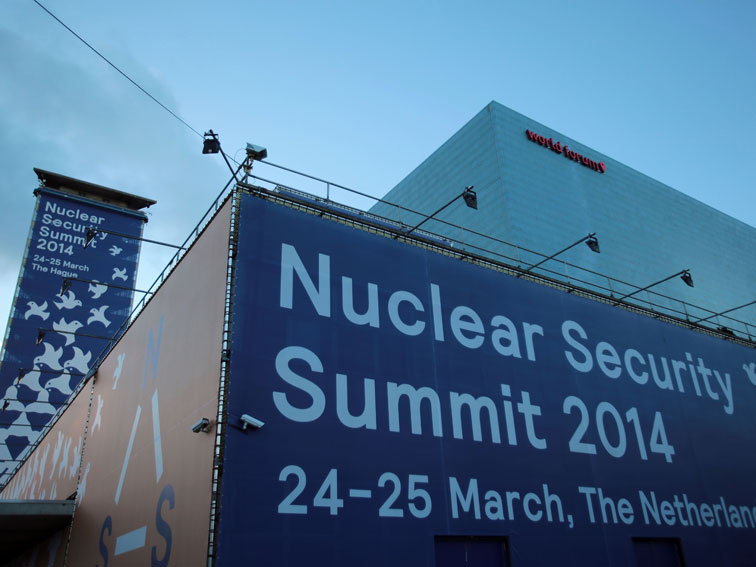 Ein großes Plakat mit der Aufschrift "Nuclear Security Summit 2014" hängt am Gebäude des World Forum.